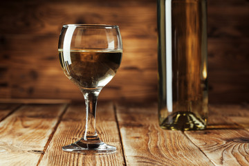 Wine bottles with glass, wooden background