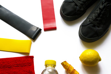 Sport background of fruits, water balance, fitness gum expanders, equipment, accessories with copy space on white. Woman gym training, healthy lifestyle, proper nutrition, diet, slim concept.