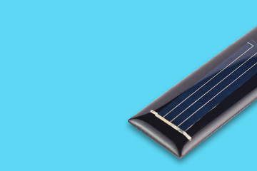One new rectangular solar cell protected of transparent silicone or resin on blue table with copy space for your text. Green or alternative or eco energy concept