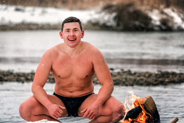 naked wet man after swimming in the winter river