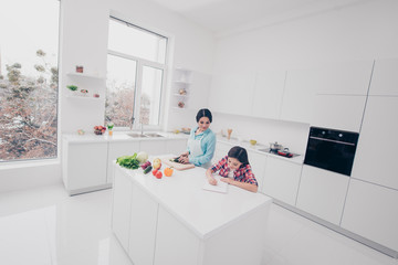Portrait of two nice lovely charming attractive stylish trendy cheerful people girl doing task mom making meal lunch snack salad in modern light white kitchen interior