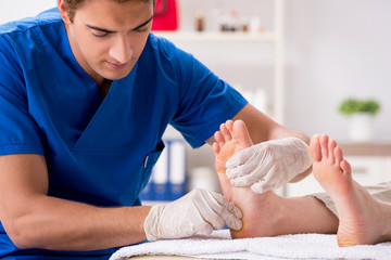 Podiatrist treating feet during procedure - obrazy, fototapety, plakaty