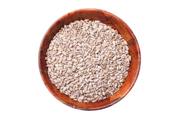 Hulled sunflower seeds in wooden bowl. Round kitchen container filled with no shell sunflower seeds isolated on white.