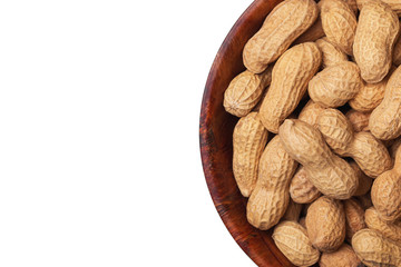 Peanuts in shells inside round wooden bowl isolated on white. Helathy vegetarian diet food background with empty copy space.