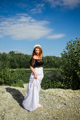 Young beautiful redhead woman on the stone