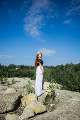 Young beautiful redhead woman on the stone