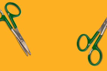 Two worn metal scissors on orange background with copy space for your text