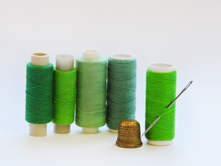 Colorful treads for sewing.Sewing supplies and accessories for needlework- scissors, needles, yellow measuring tape, thread on a table. Close up group of Multicolored spools of thread use to sewing. 