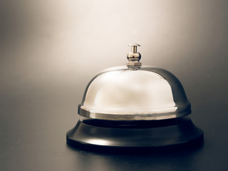 bell at the reception desk made of metal on a black background.