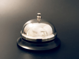 bell at the reception desk made of metal on a black background.