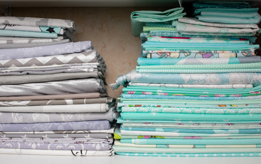 lots of bundles of different verities of new fabric in many color collections kept on the shelf of a local store in Asia