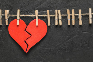 Broken heart hanging on rope with copy space. Valentine's Day background