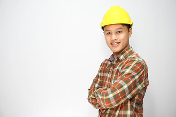 The electrician wears a yellow safety helmet standing in his arm