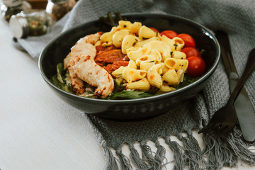 close-up of plate of pasta and chicken with lettuce