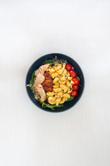 close-up of plate of pasta and chicken with lettuce