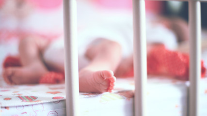 legs of a newborn baby lying in a cot