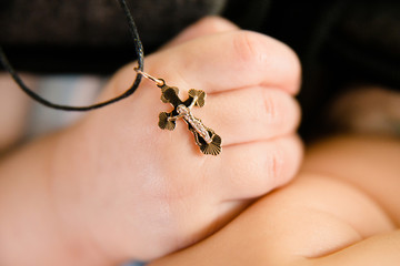 Obraz premium Christian cross in the hand of the baby