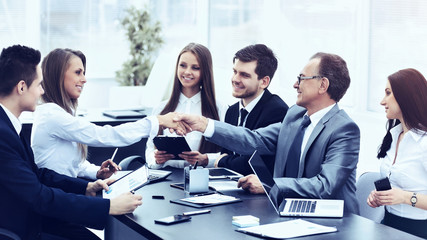 Business meeting at the table and handshake of  partners