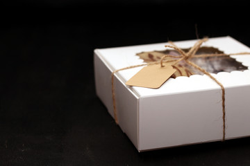 white box with a transparent cover, tied with a rope, with cookies and a label for text on a dark background. A gift for Valentine's Day, Mother's Day, Birthday