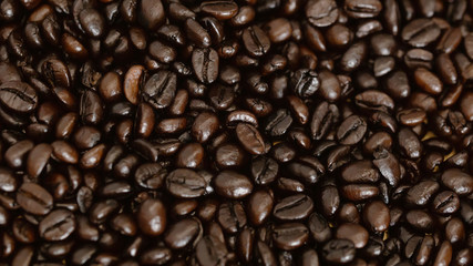 Heap of dark color of raw coffee beans texture for background.