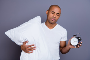 Close up photo sick mad unhealthy dark skin he him his macho bald head hold clock pillow sleep and walk sleepless night wearing white t-shirt outfit clothes isolated grey background