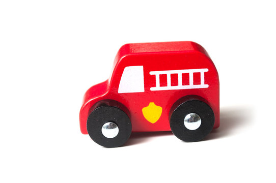 closeup of red  miniature wooden truck on white background - concept fire rescue