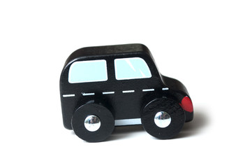 closeup of miniature wooden car on white background - concept british taxi
