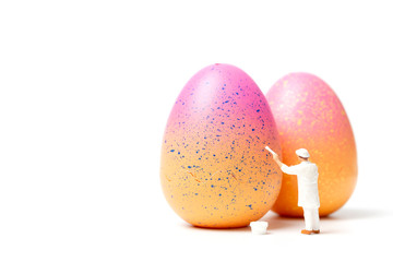 Miniature people  painting Easter-eggs for Easter day on white background 