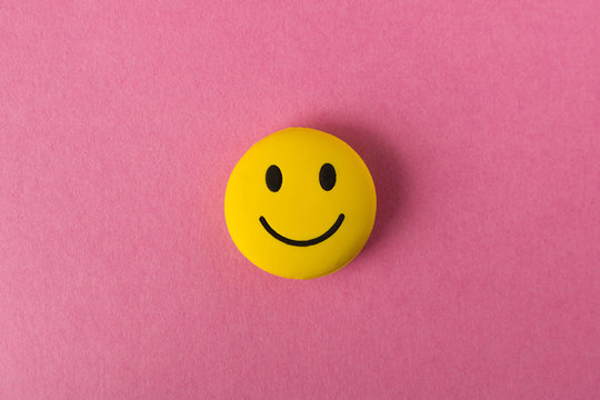 Funny smiley face on pink background. Positive mood. Empty text space.