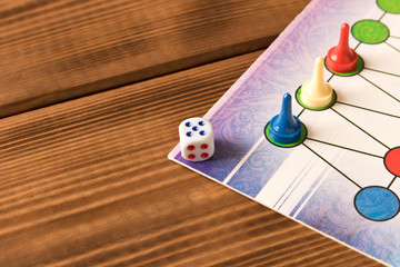 Multi-colored game chips with dice on the playing board. Board game concept.
