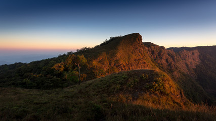 Mountain landscape with the sunrise and orange horizon of sunlight at morning, Thailand. 