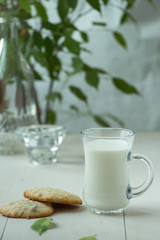 Oatmeal cookies with a glass of milk, light and white photography in a rustic style, village and countryside wooden theme