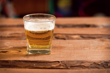 Glass with beer on a wooden background.