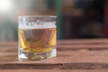 Glass with beer on a wooden background.