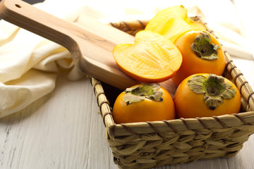 persimmon in a basket on a light background