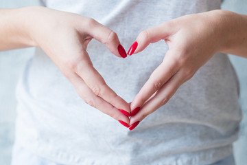 Romantic concept. Woman hands showing love heart symbol.