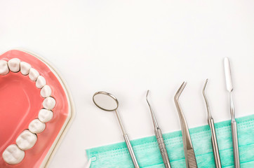 Dentist tool with mask and teeth model.