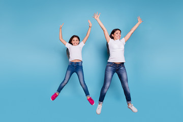 Fototapeta na wymiar Full length body size view of two nice lovely attractive charming cheerful funny slim people in white t-shirt jeans denim raising hands up party isolated over blue pastel background