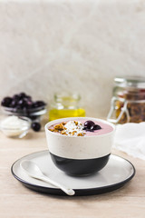 Healthy breakfast, cherry smoothie with granola, honey and coconut flakes. Selective focus, space for text.