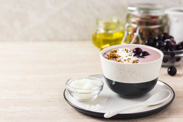 Healthy breakfast, cherry smoothie with granola, honey and coconut flakes. Selective focus, space for text.