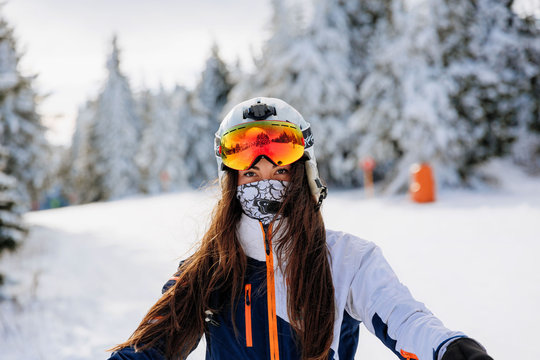 Ski, skier, sun and winter fun - woman enjoying ski vacation. Sport, leisure and people concept - happy young woman in ski goggles outdoors. Ski resort - Image