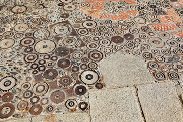 Unusual floor with pattern from pebbles, brick and rusty metal details
