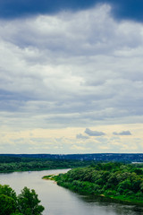 Fototapeta premium River and sky before the storm. Ship, steamer on the horizon. Summer river in cloudy day. Coastal area, beach, lake bank. Amazing summer landscape with meadow, trees for nature calendar, poster, print