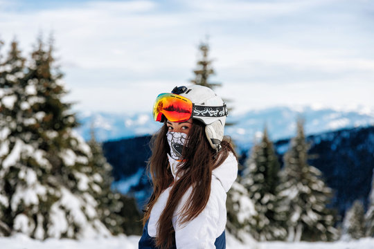 Happy girl dressed in ski or snowboard fashion mask goggles. Mountain landscape. Extreme adventure. - Image
