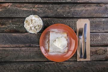 Strudel with an apple and vanilla ice cream, served on the ceramic plate with the cutlery and the glass of beverage.