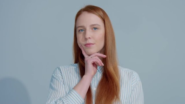 portrait of gingerhead model lifting up brow and watching to the camera. Women in doubts portrait