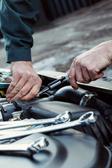Mechanic repairs car. Car service, engine repair, car repair shop. Place for text.