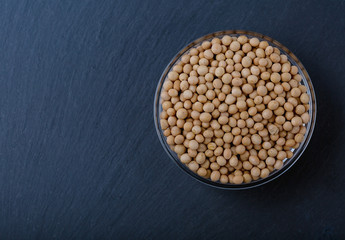 Raw dry soybeans as a vegetable protein on black background.