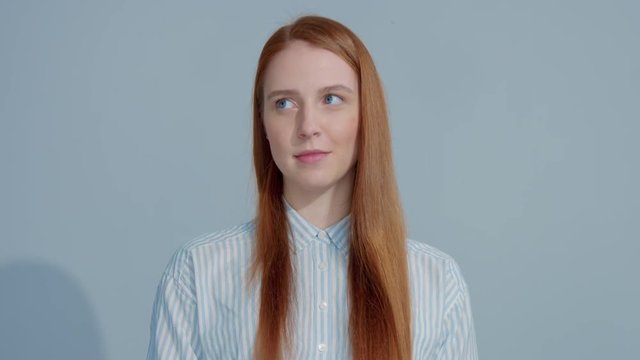 pretty young gingerhead model watching from side to side, lift up her brow, little bit surprised