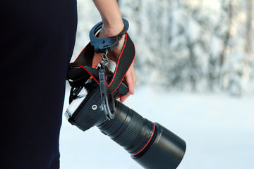 Girl with a camera in hand. Fastened with handcuffs.